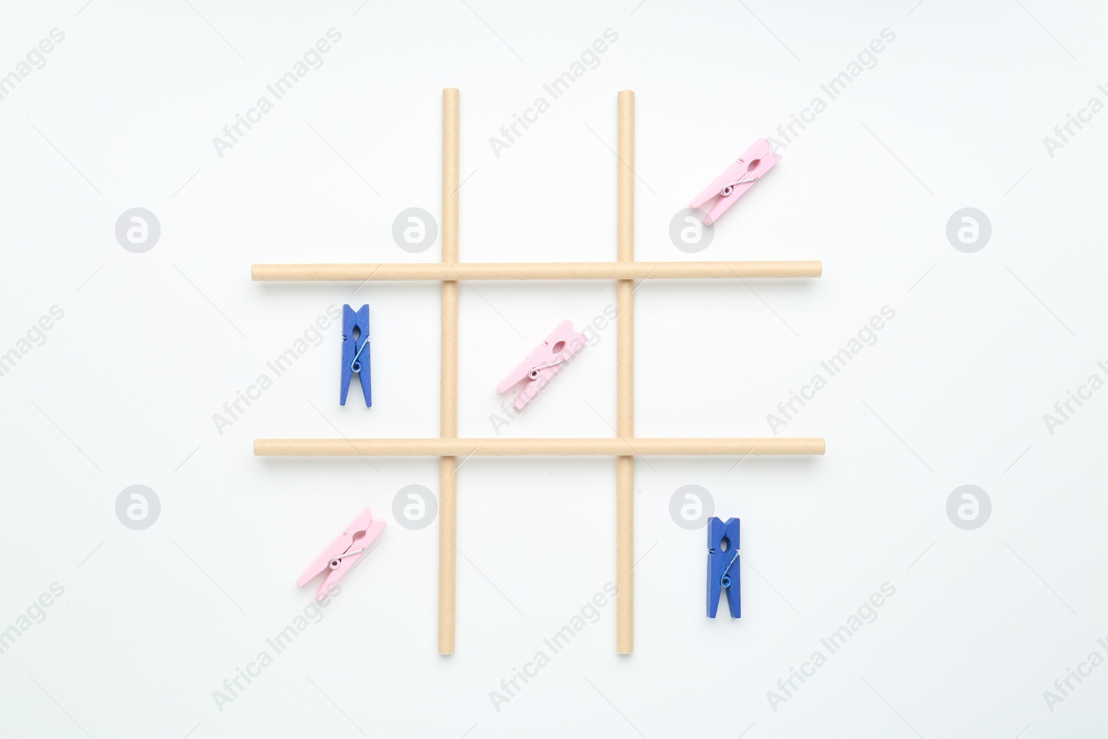 Photo of Tic tac toe game made with clothespins on white background, top view