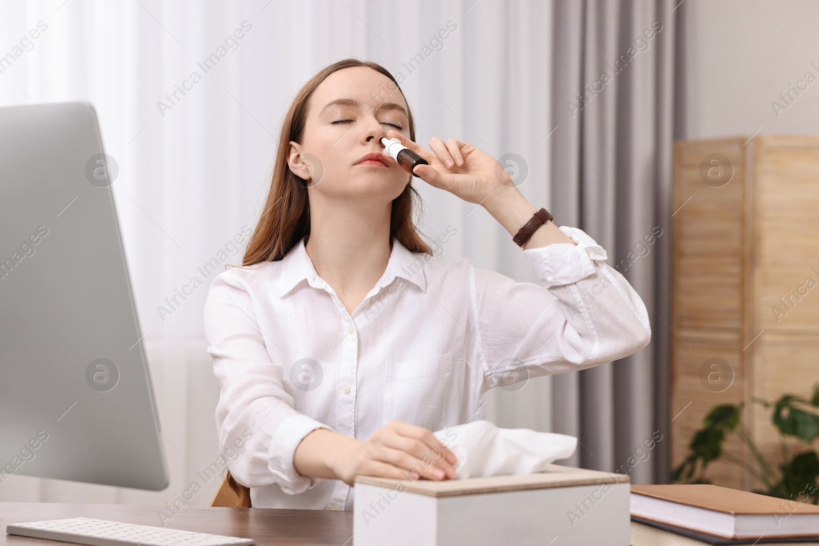 Photo of Medical drops. Young woman using nasal spray at home indoors