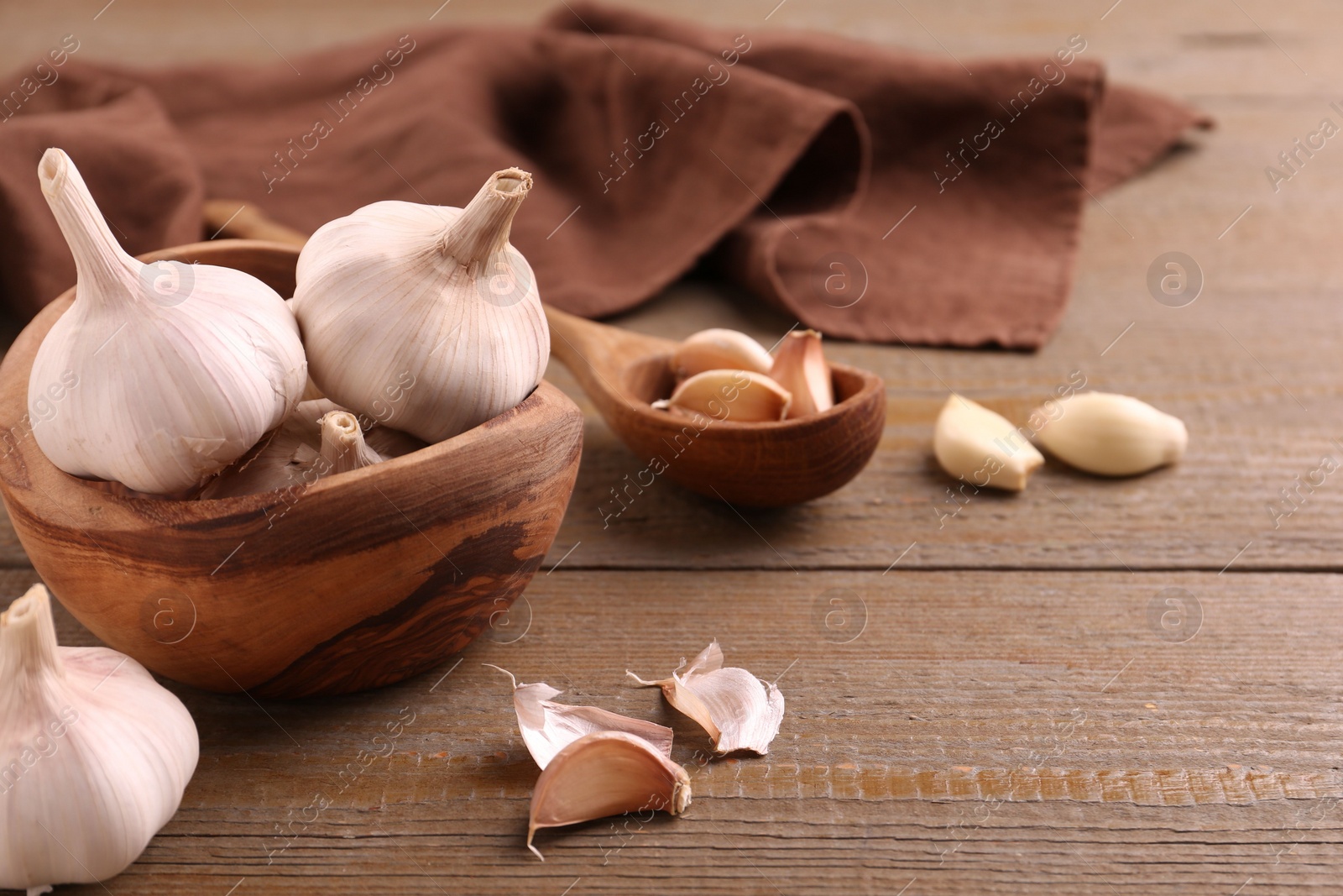 Photo of Fresh garlic on wooden table, closeup. Space for text