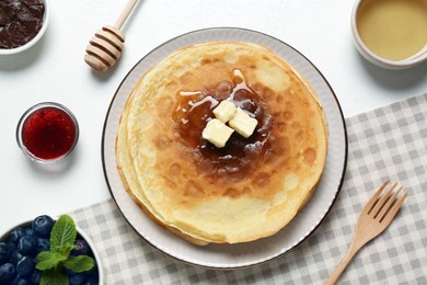 Photo of Delicious crepes with different products on white table, flat lay