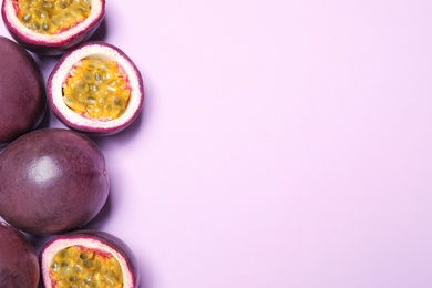 Fresh ripe passion fruits (maracuyas) on light pink background, flat lay. Space for text