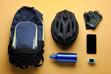 Photo of Flat lay composition with different cycling accessories on pale orange background
