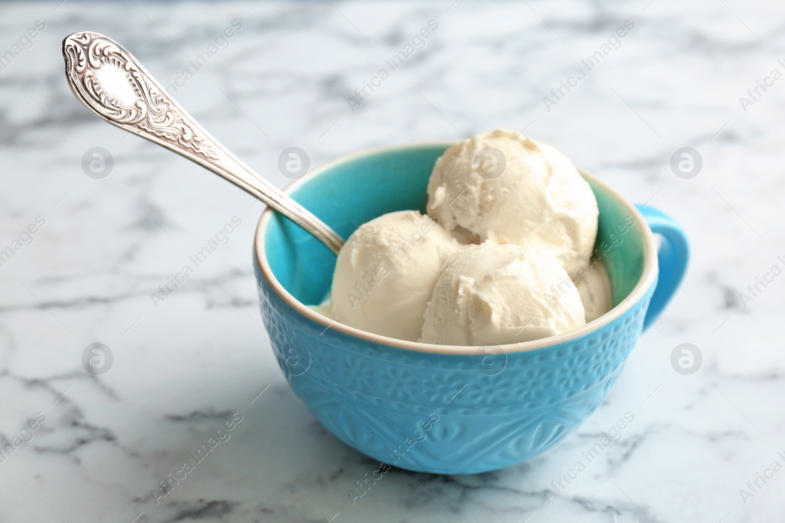 Photo of Cup with tasty vanilla ice cream on light background