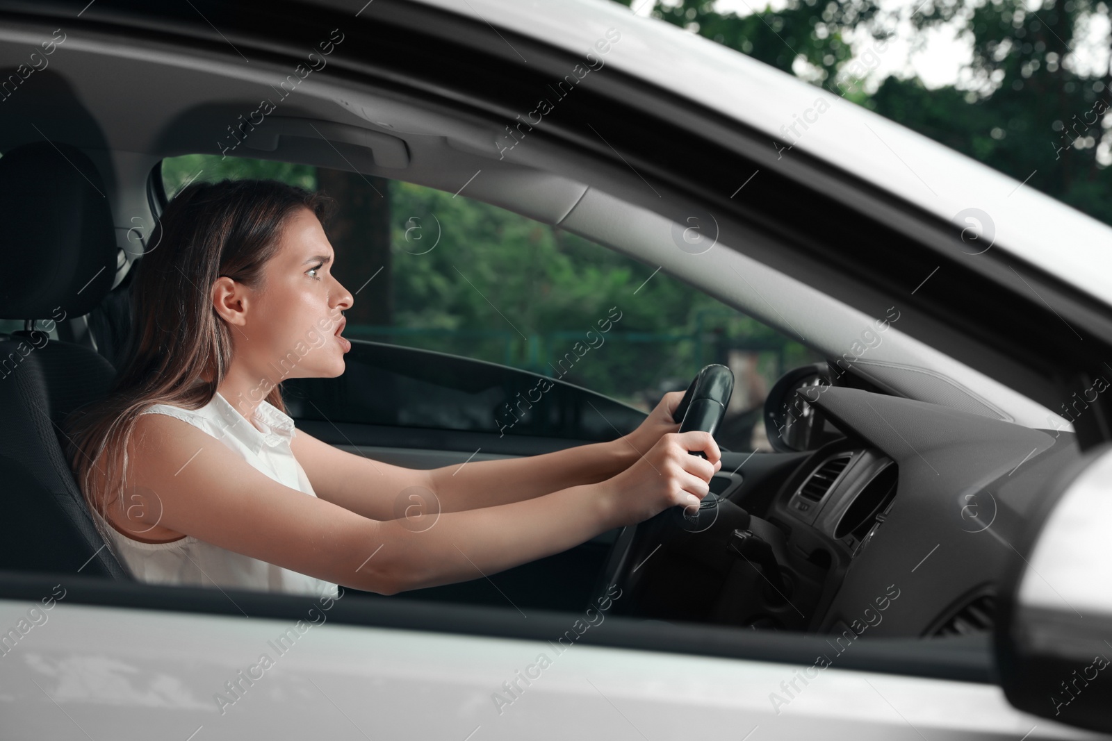 Photo of Stressed young woman in driver's seat of modern car