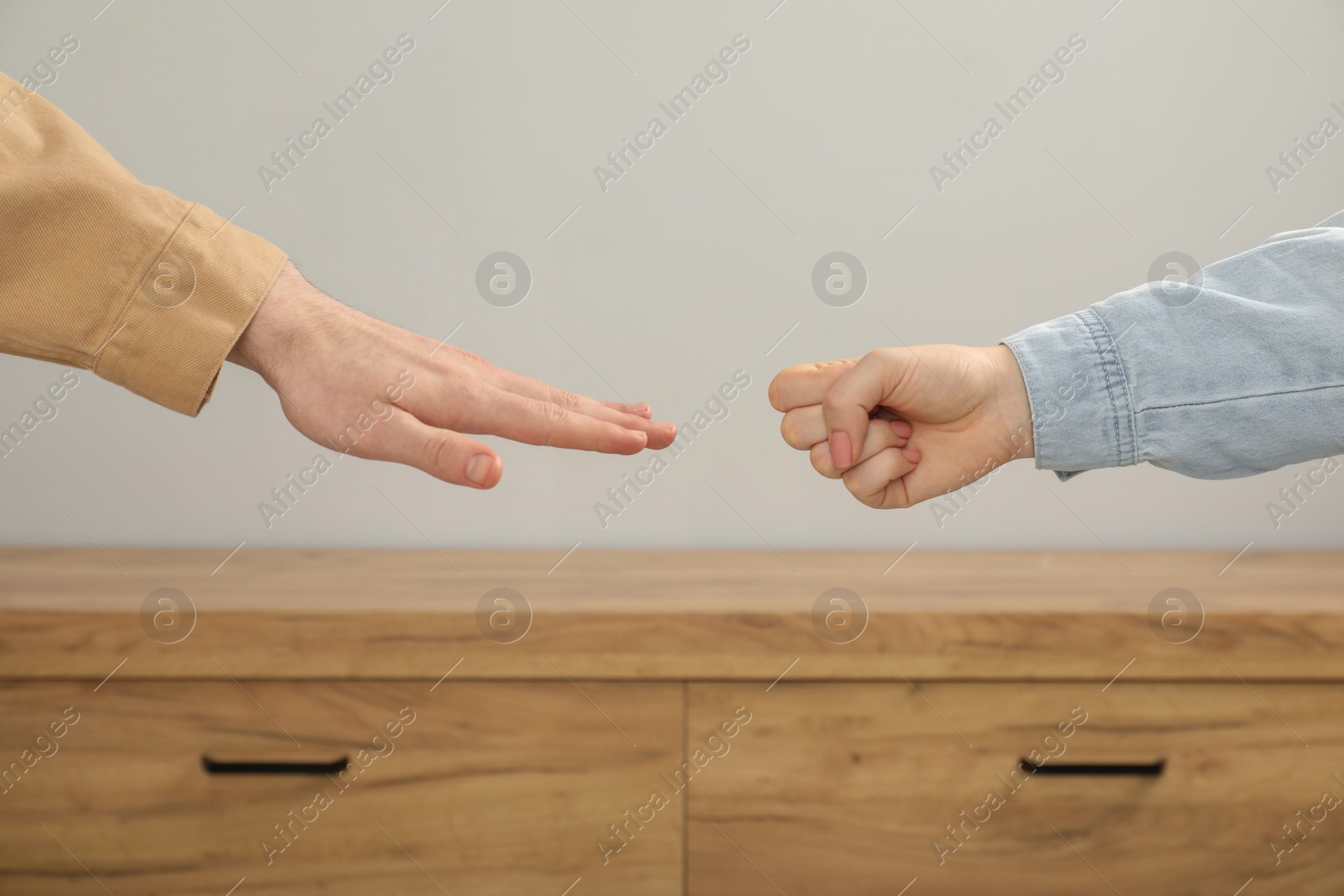 Photo of People playing rock, paper and scissors indoors, closeup