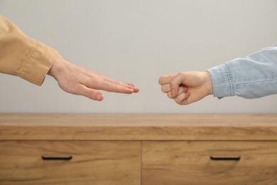 Photo of People playing rock, paper and scissors indoors, closeup