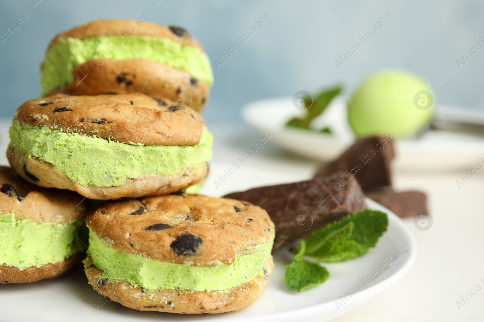 Photo of Plate with sweet delicious ice cream cookie sandwiches on table, closeup. Space for text