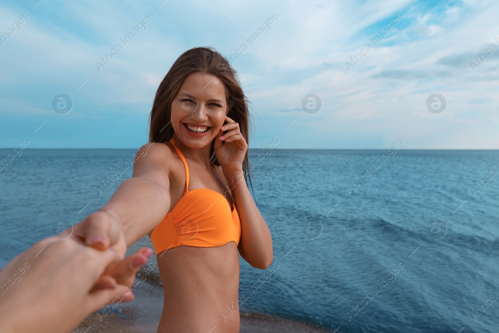 Photo of Young woman in bikini with girlfriend on beach. Lovely couple