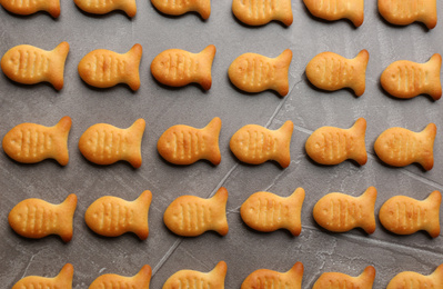 Photo of Delicious goldfish crackers on grey table, flat lay