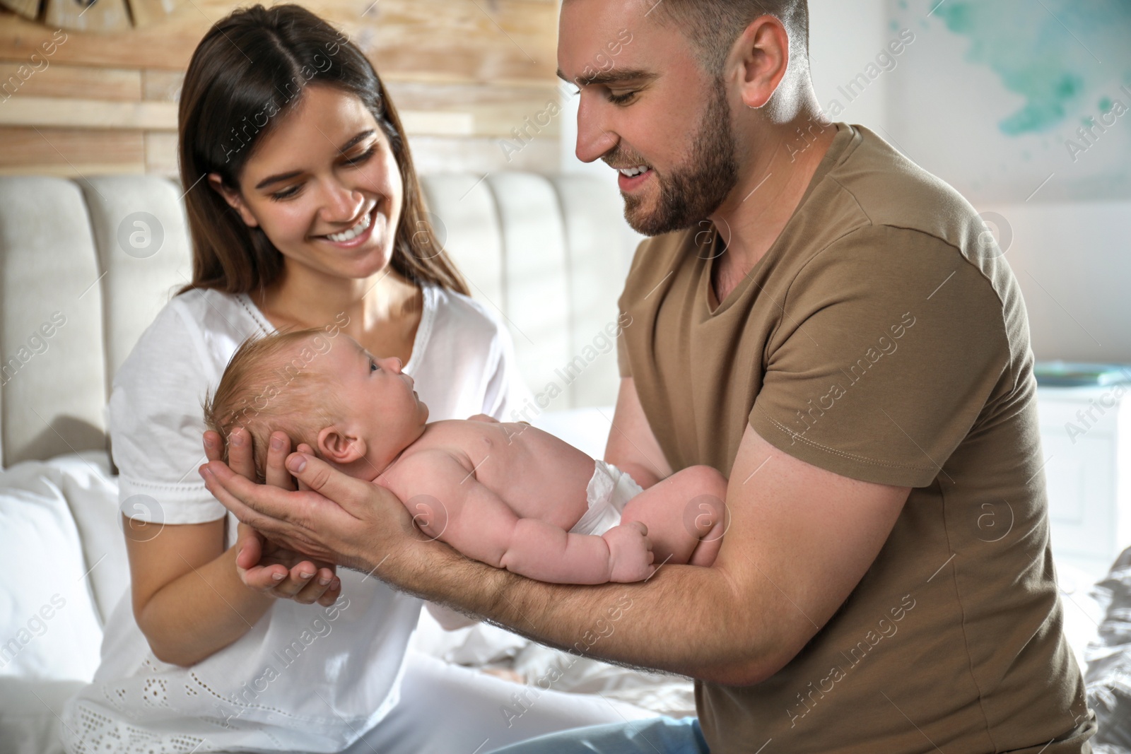 Photo of Happy couple with their newborn baby at home