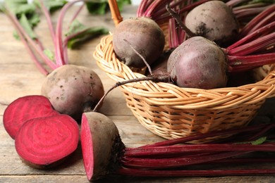 Photo of Cut and whole raw beets on wooden table