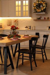 Cozy dining room interior with beautiful Christmas wreath and festive decor