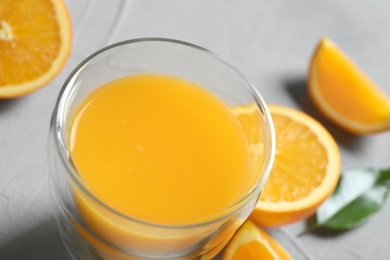 Glass of orange juice and fresh fruits on table, closeup