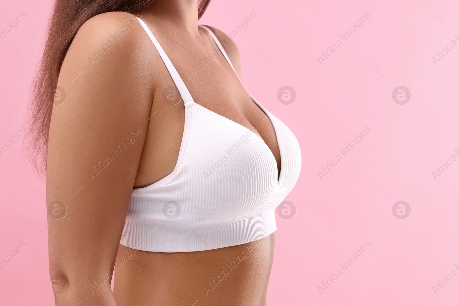 Photo of Woman with beautiful breast on pink background, closeup. Space for text