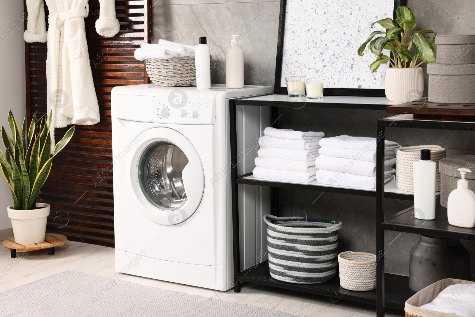 Photo of Stylish laundry room with modern washing machine. Interior design