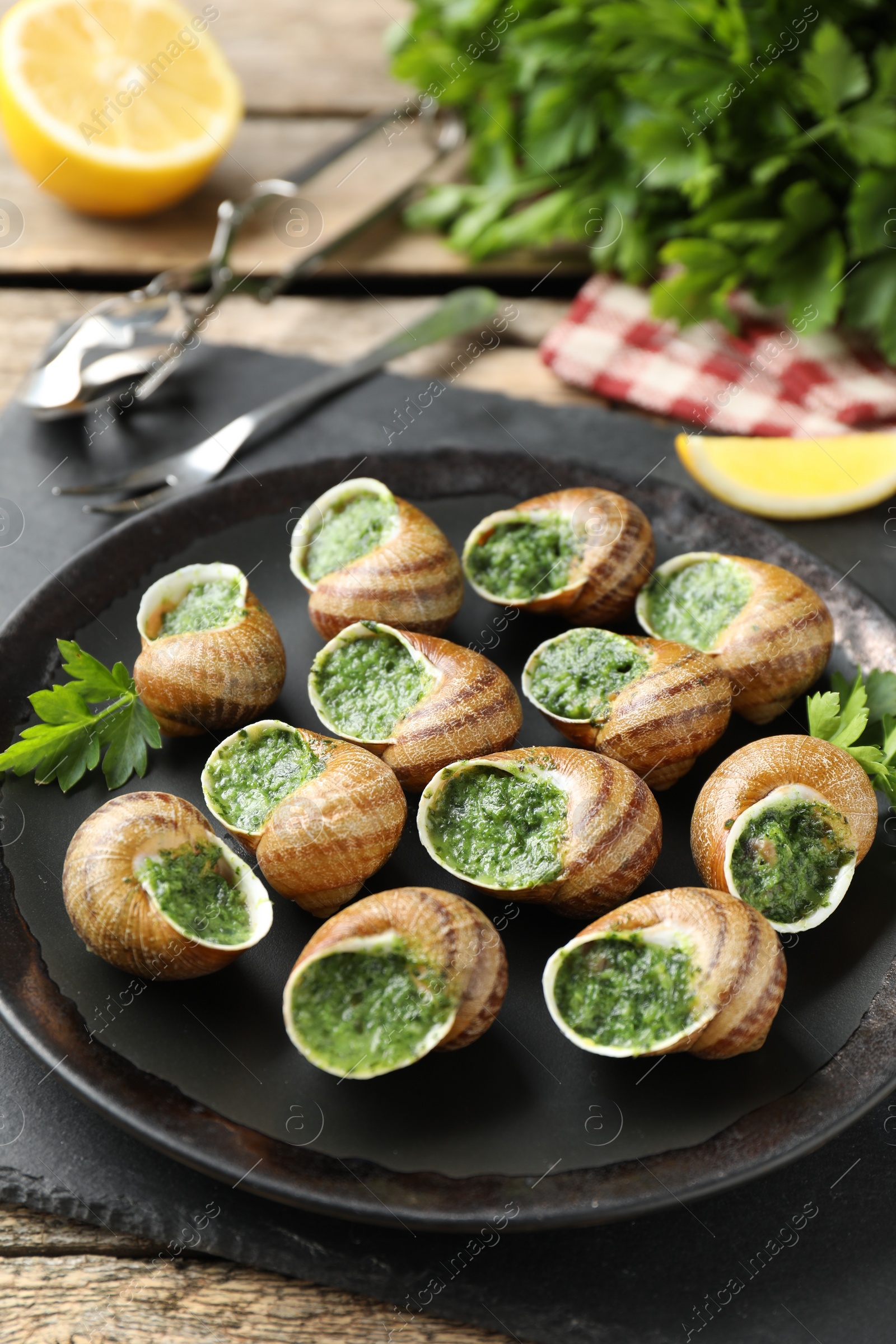 Photo of Delicious cooked snails with parsley on table, closeup