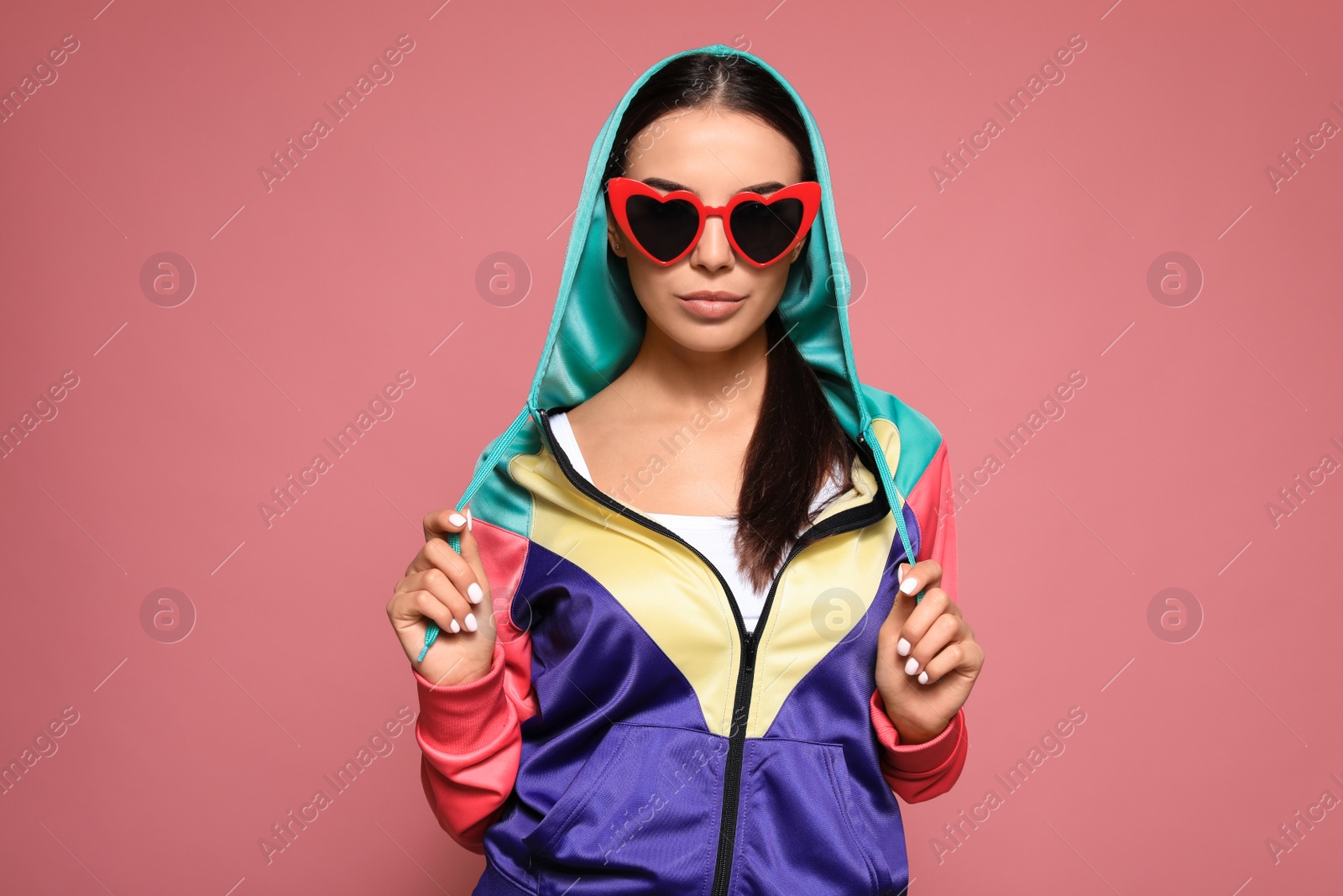 Photo of Portrait of beautiful young woman with heart shaped sunglasses on color background