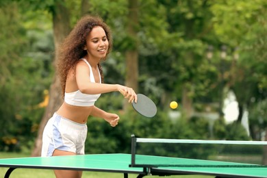 Photo of Young African-American woman playing ping pong outdoors