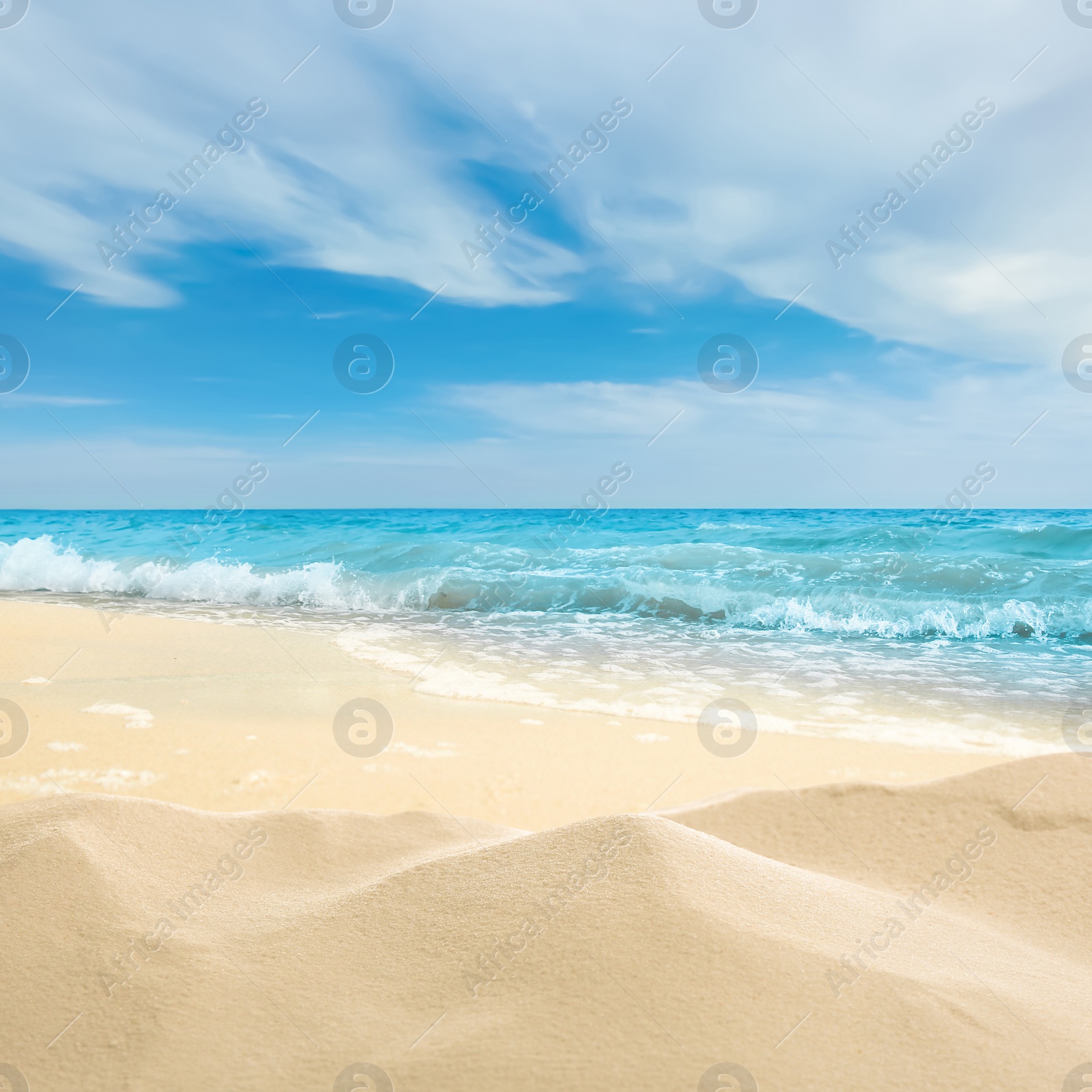 Image of Ocean waves rolling on sandy beach under blue sky with clouds