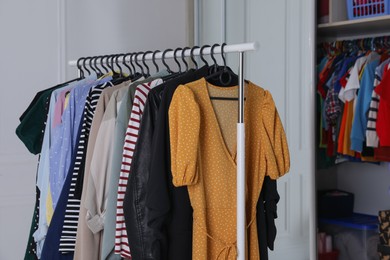 Rack with stylish women's clothes in dressing room