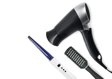 Image of Hair dryer, round brush and curling iron on white background, top view