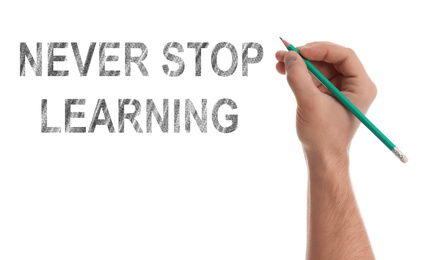 Image of Man writing phrase NEVER STOP LEARNING on white background, closeup