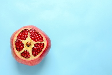 Photo of Ripe red pomegranate fruit with juicy seeds on color background, top view. Space for text