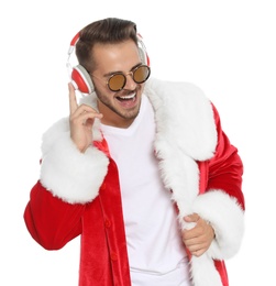 Photo of Young man in Santa costume listening to Christmas music on white background