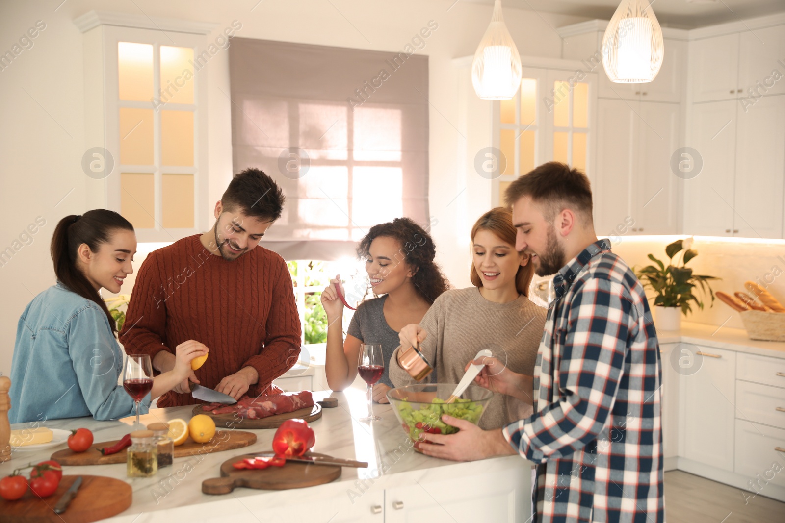 Photo of Happy people cooking food together in kitchen