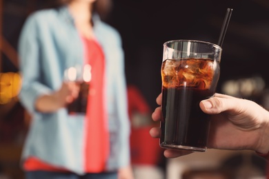 Photo of Man holding glass of cola in bar, closeup. Space for text