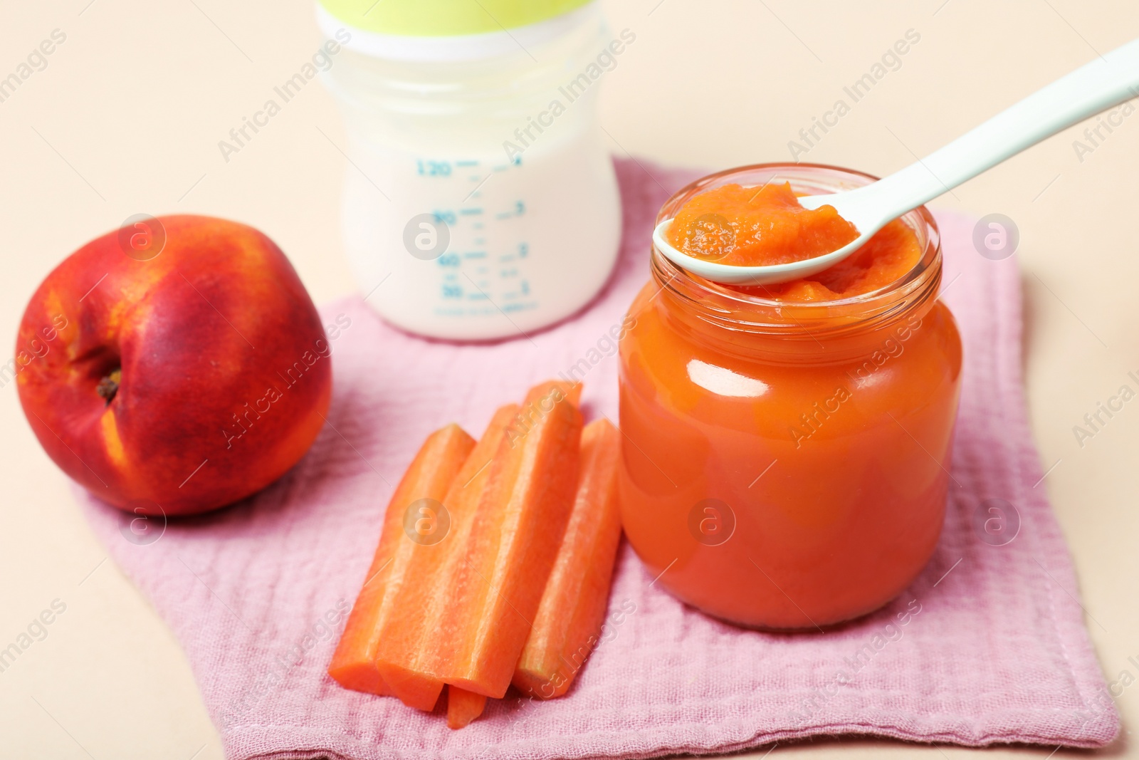 Photo of Healthy baby food and ingredients on pale pink background, closeup