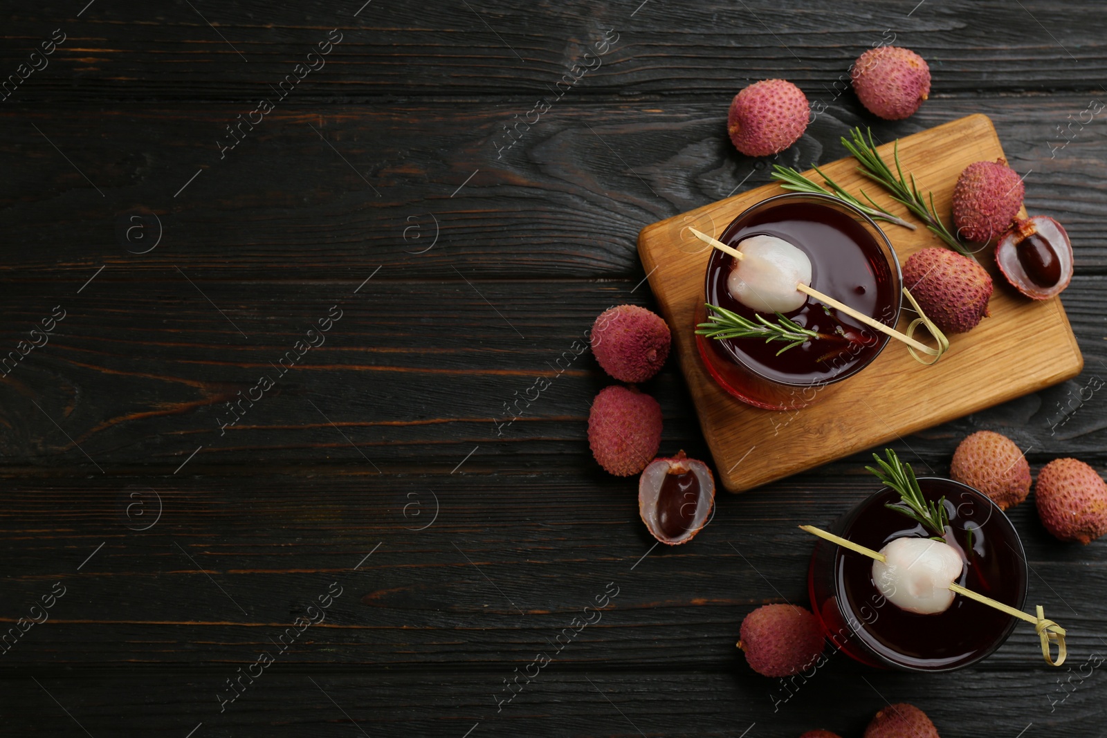 Photo of Flat lay composition with lychee cocktail on dark wooden table. Space for text