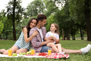 Happy family having picnic in park on summer day