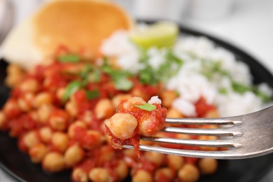 Photo of Fork with delicious chickpea curry, closeup view