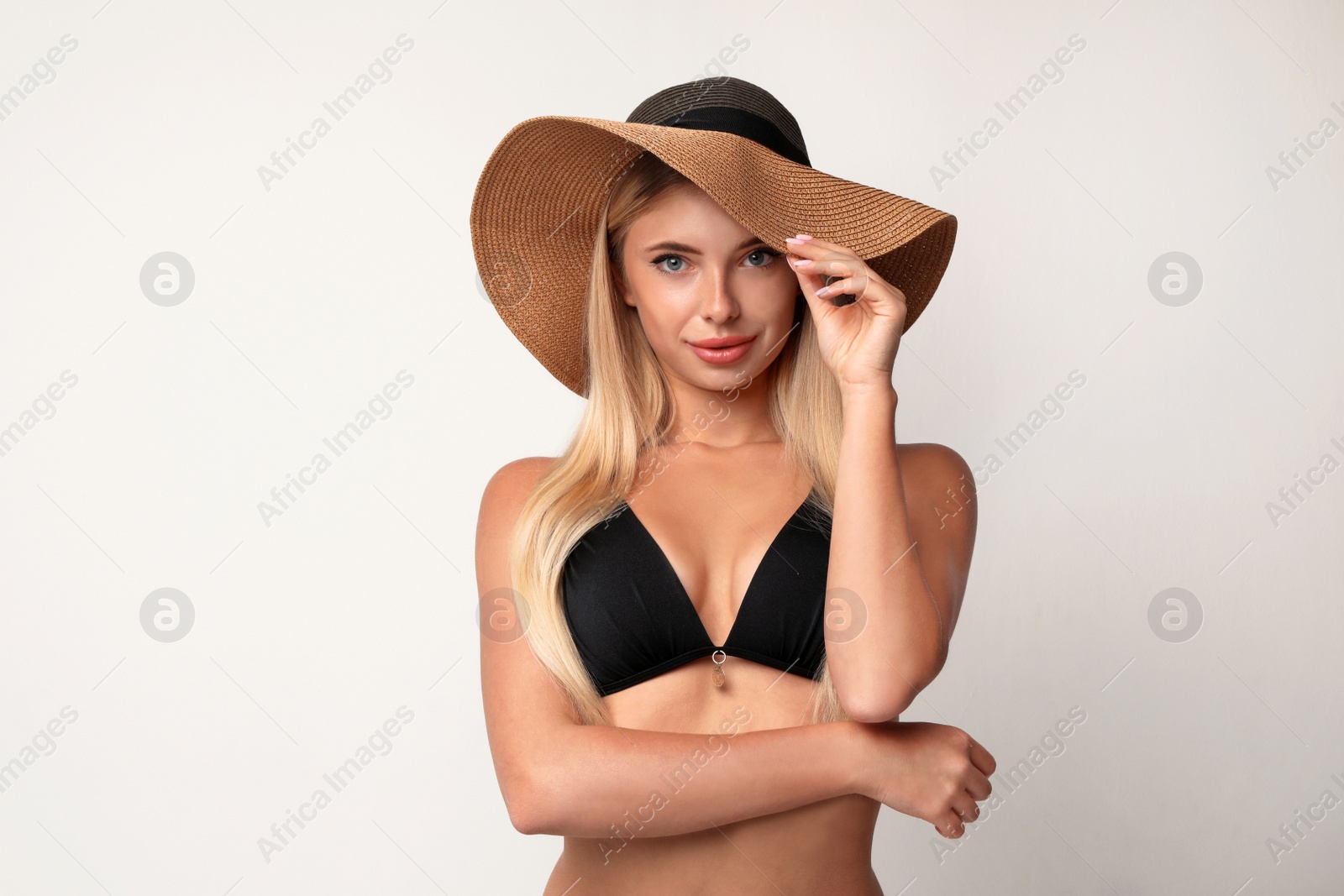 Photo of Pretty young woman wearing stylish bikini on light background