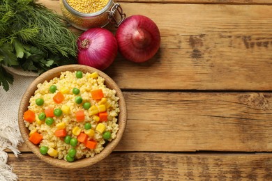 Photo of Tasty millet porridge with vegetables in bowl and products on wooden table, flat lay. Space for text