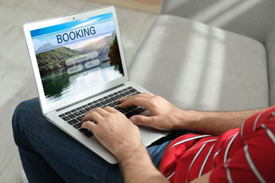 Man using laptop to plan trip, closeup. Travel agency website