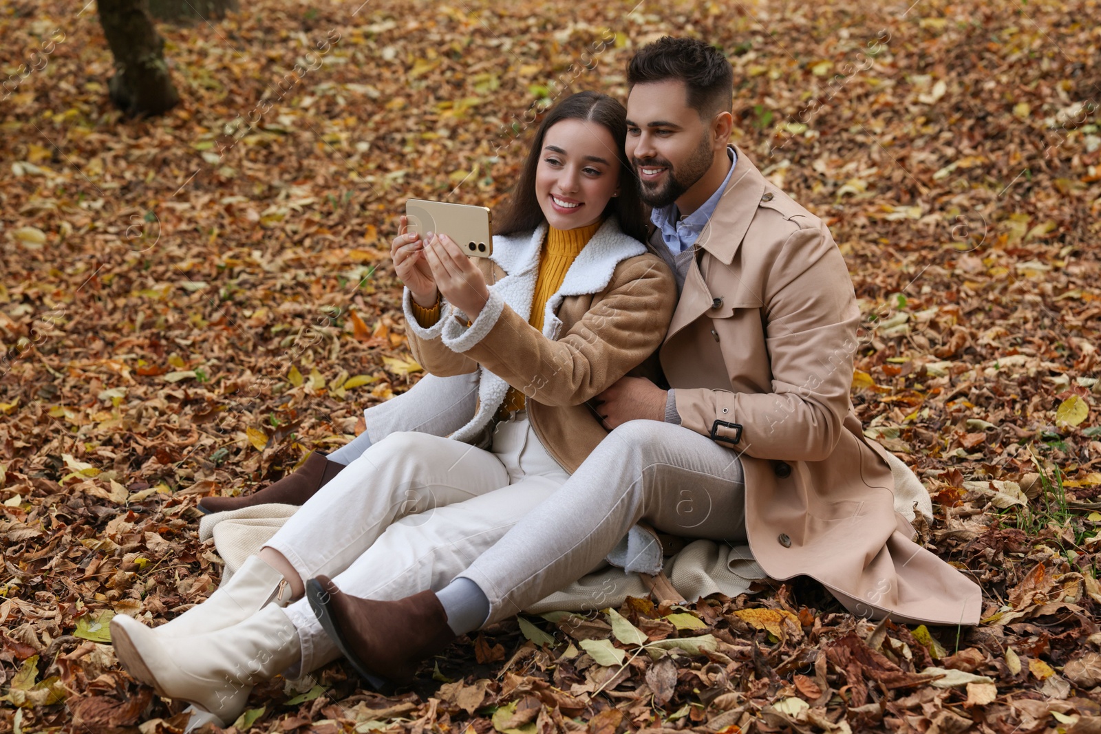 Photo of Happy young couple taking selfie in autumn park