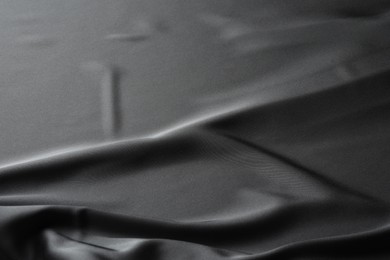 Texture of black crumpled silk fabric as background, closeup