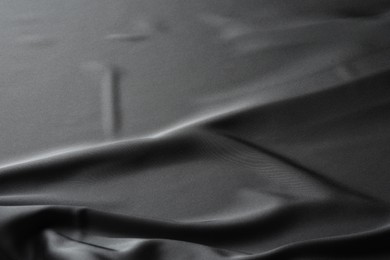 Photo of Texture of black crumpled silk fabric as background, closeup