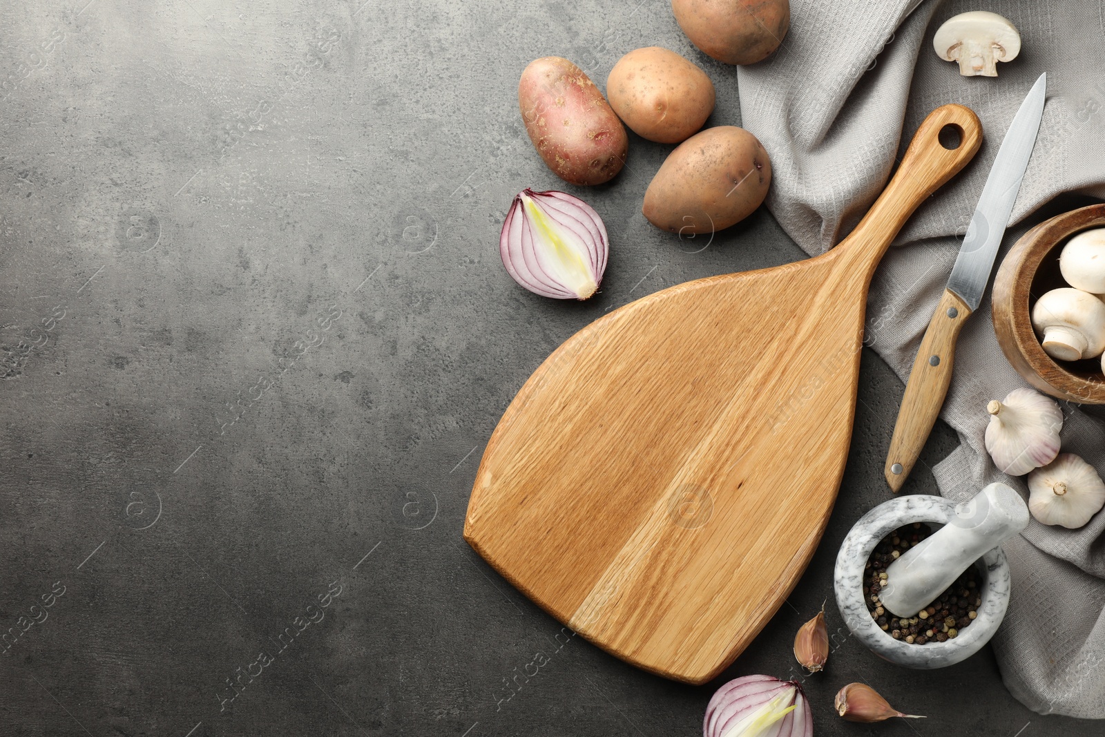 Photo of Flat lay composition with wooden cutting board and products on dark textured table. Space for text