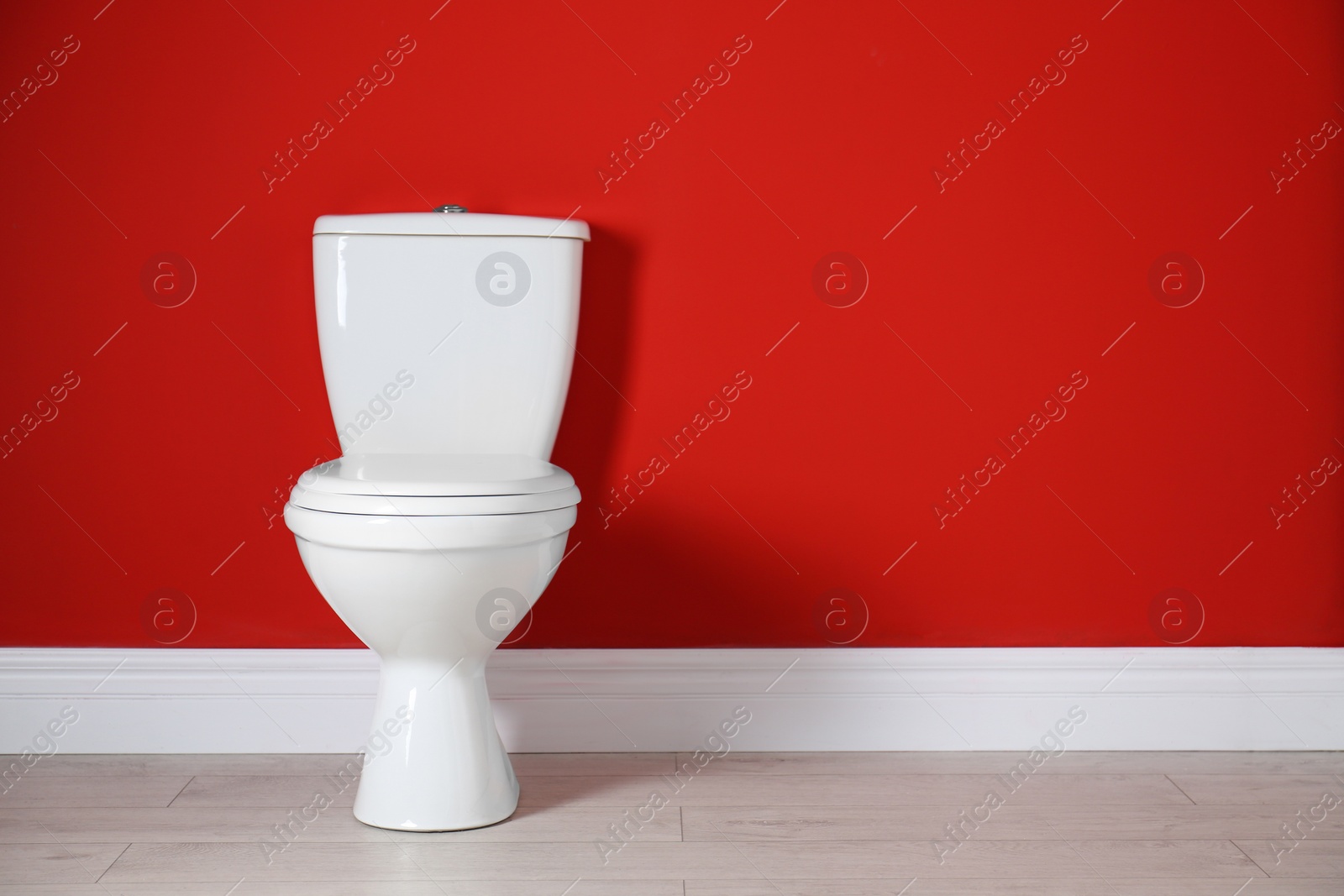 Photo of Toilet bowl near color wall in restroom. Space for text