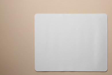 Photo of One mouse pad on beige background, top view. Space for text