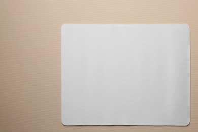 One mouse pad on beige background, top view. Space for text