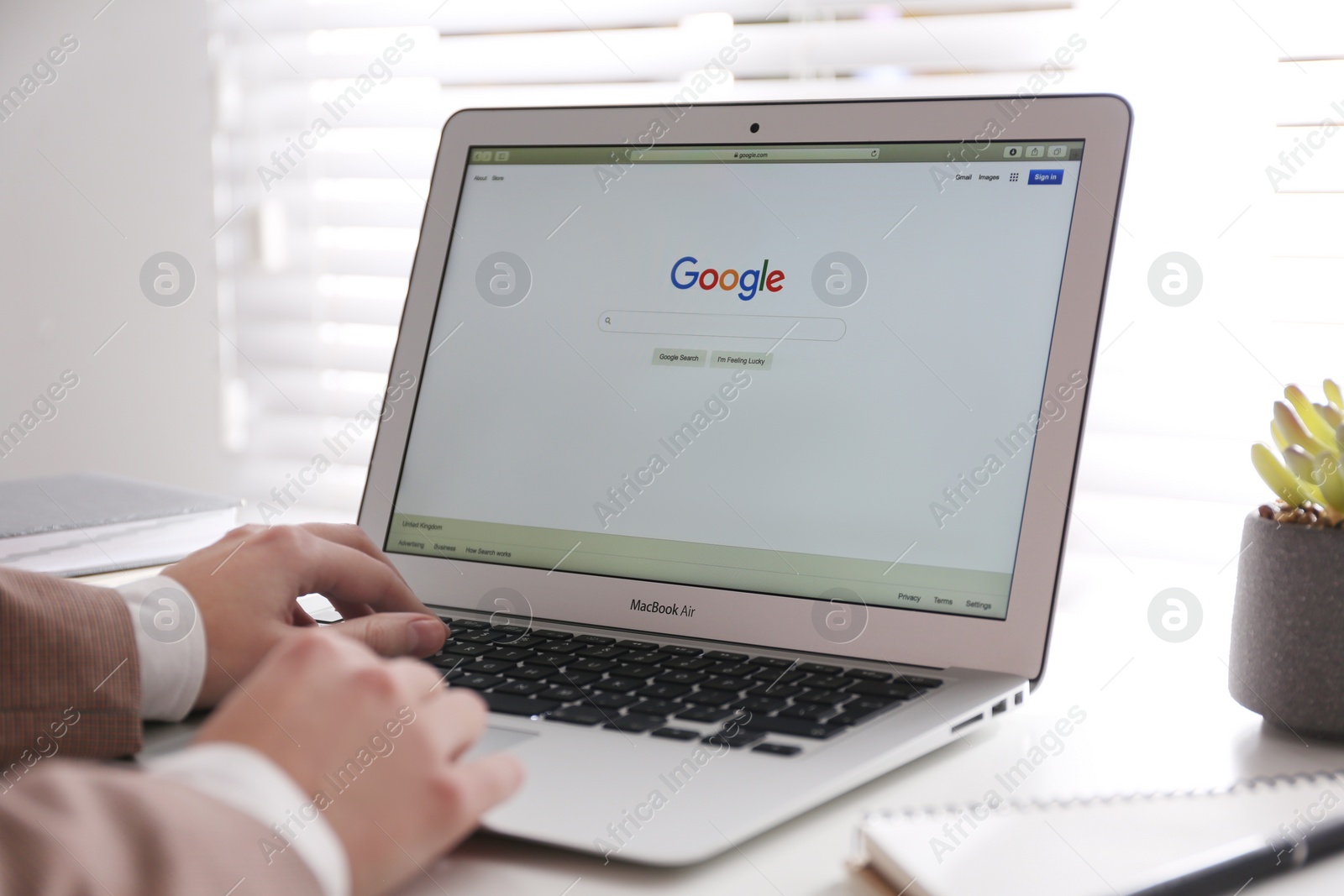 Photo of MYKOLAIV, UKRAINE - NOVEMBER 13, 2020: Woman using Google search on Apple Macbook Air in office, closeup