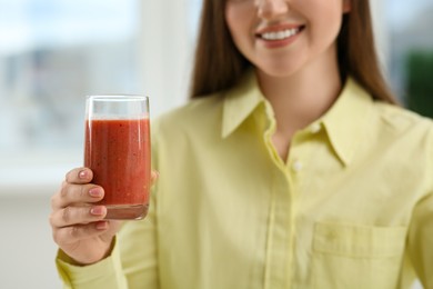 Photo of Beautiful young woman with delicious smoothie on blurred background, closeup