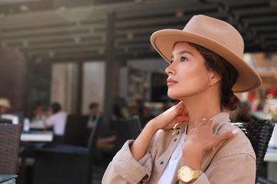 Photo of Portrait of beautiful young woman in outdoor cafe. Space for text