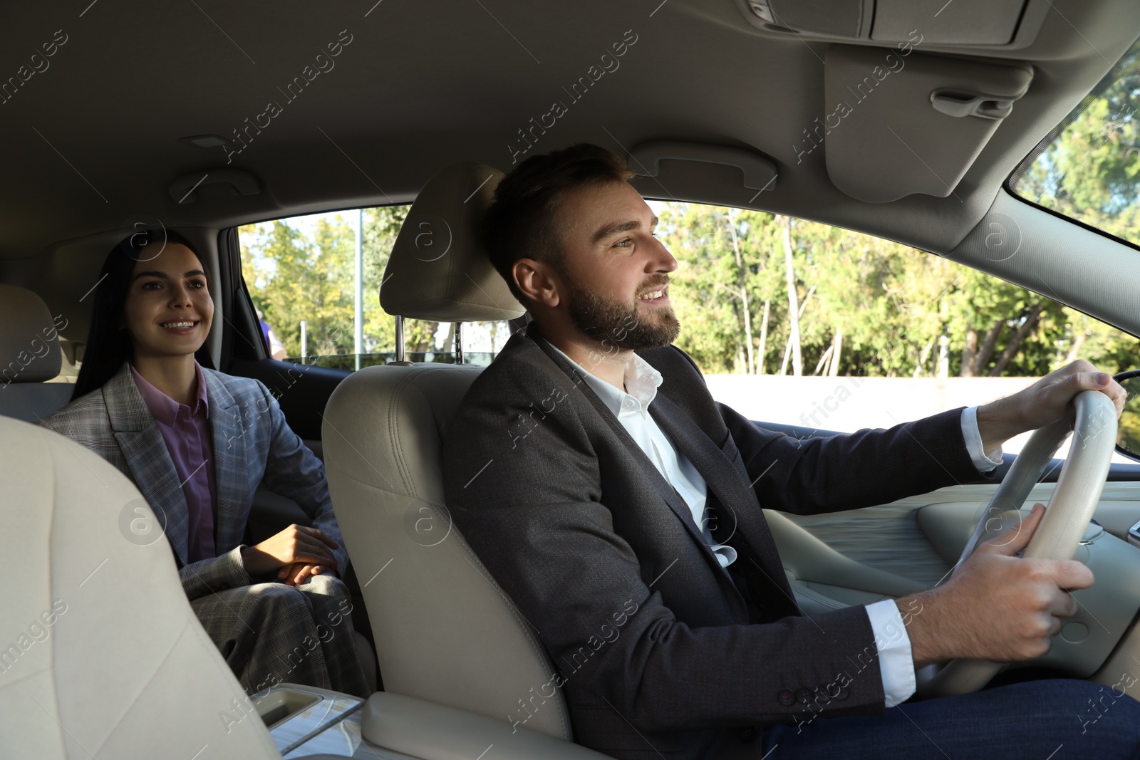 Photo of Young woman and driver in modern car