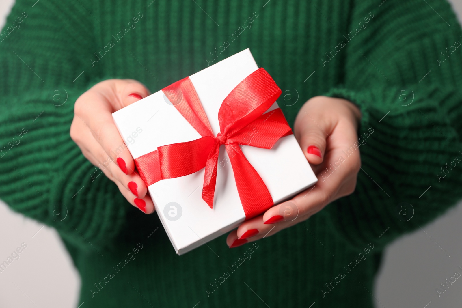 Photo of Christmas present. Woman holding gift box, closeup