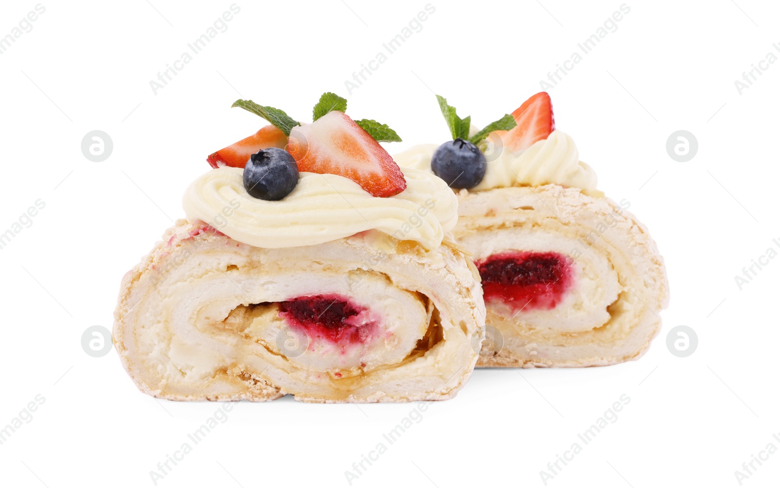 Photo of Slices of tasty meringue roll with jam, berries and mint leaves isolated on white